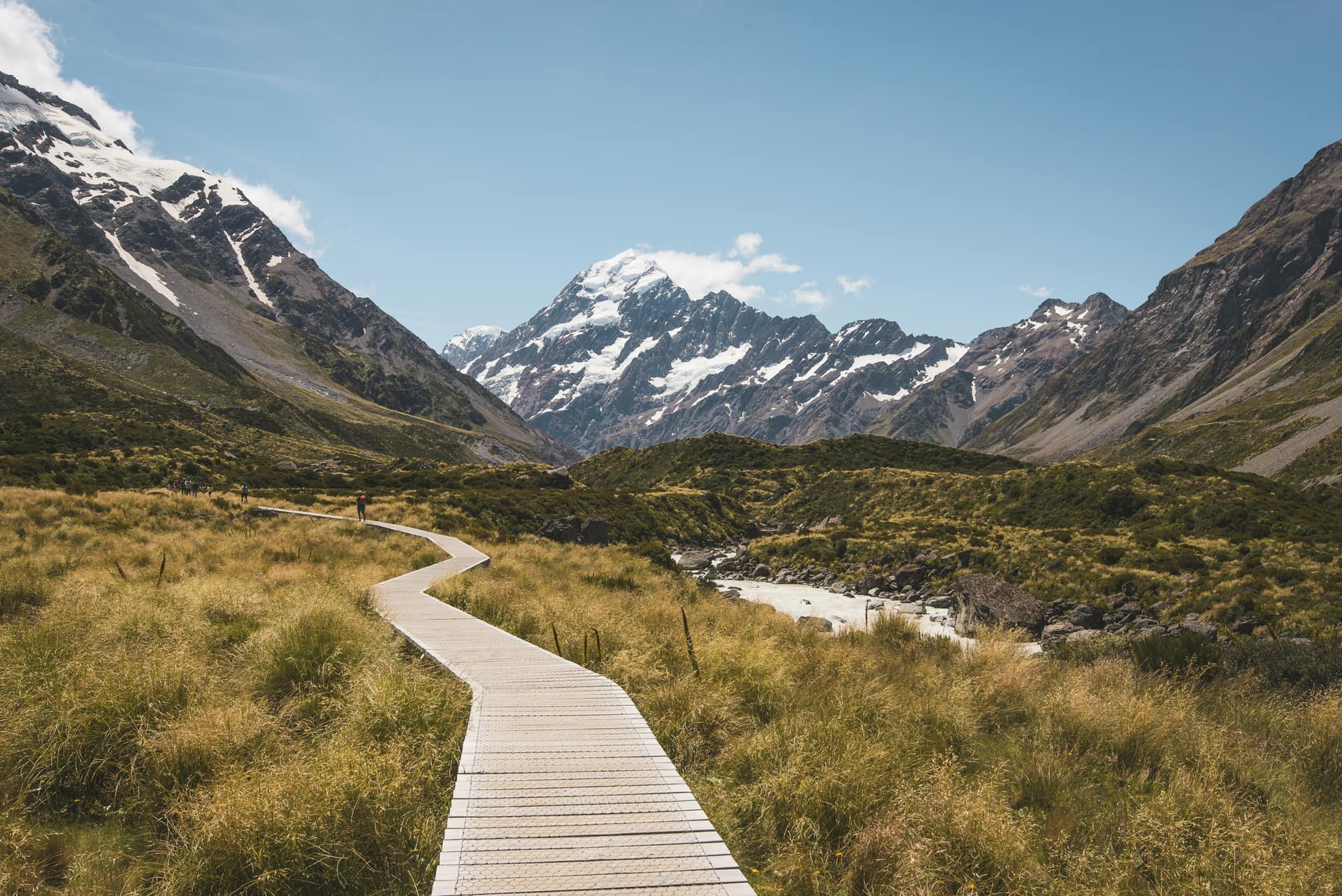 Boardwalk trail through alpine grassland leading toward Aoraki / Mount Cook, New Zealand